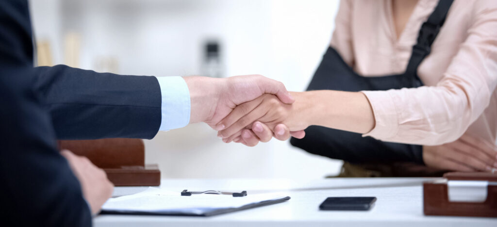 Injured worker shaking hands with insurance agent